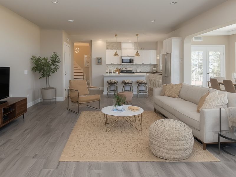 Wall colors for gray wood floors in an open concept living room, featuring creamy beige paint and warm mid-century modern design.